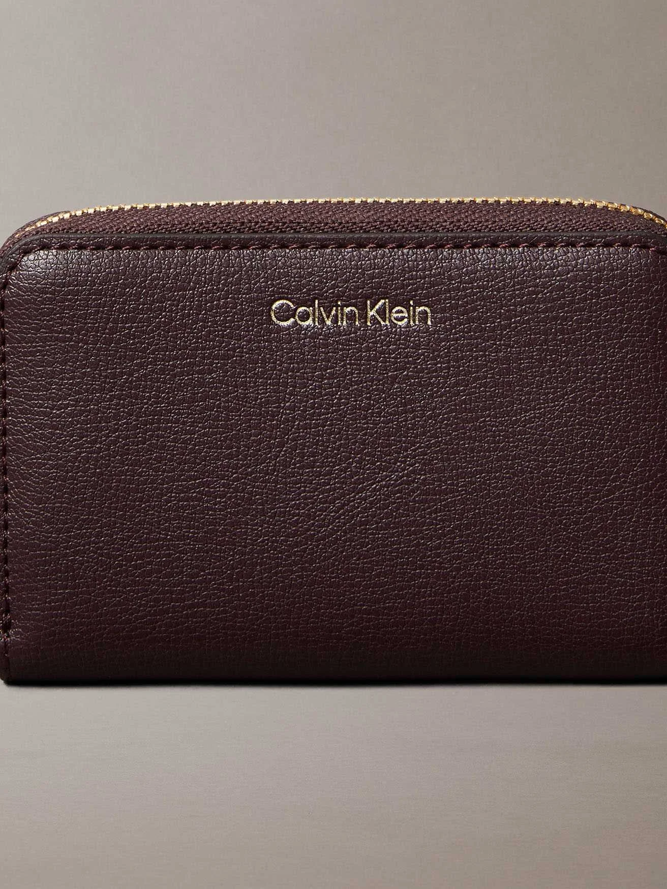 CALVIN KLEIN - FOIL LOGO MEDIUM ZIP... CALVIN KLEIN - FOIL LOGO MEDIUM ZIP...